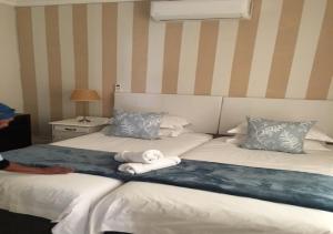 ein Hotelzimmer mit 2 Betten und Handtüchern darauf in der Unterkunft Wagon Wheel Country Lodge in Beaufort West