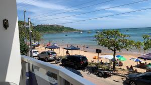 a view of a beach with cars and umbrellas at Apartamento 3 quartos Beira Mar in Anchieta