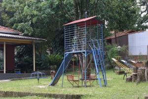 a playground with a blue slide in a yard at Stefano Hotel in São Roque
