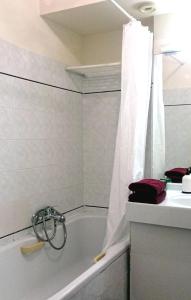 La salle de bains blanche est pourvue d'une baignoire et d'un lavabo. dans l'établissement Cosy 5 min to Beach, à Nice