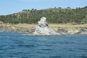 a rock formation in the middle of the water at Hostal Juventus in Portbou
