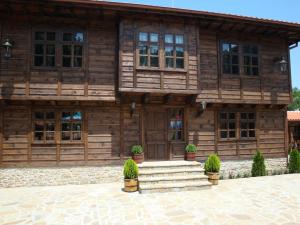 a wooden house with stairs in front of it at Voevodski Eco Complex in Katunishte