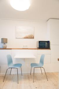 2 Stühle und ein Tisch in der Küche in der Unterkunft Smaaland in Flensburg