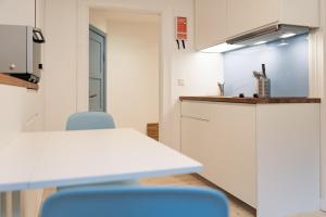 eine Küche mit einem Tisch und blauen Stühlen in einem Zimmer in der Unterkunft Smaaland in Flensburg