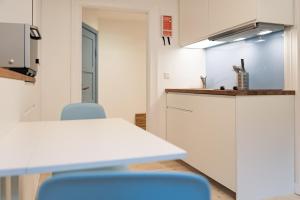 a kitchen with a table and blue chairs in a room at Smaaland in Flensburg +16 photos