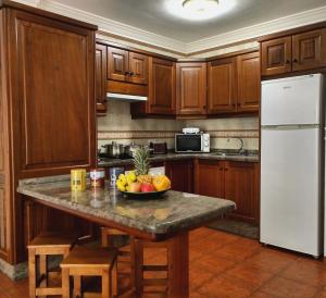 a kitchen with a table with a bowl of fruit on it at Apartamentos El Jablito in Frontera