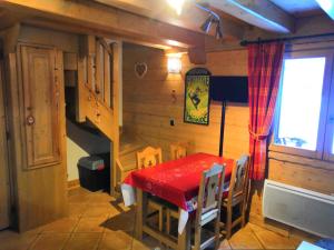 a dining room with a red table and chairs at Le Refuge des Marmottes in Sainte-Foy-Tarentaise