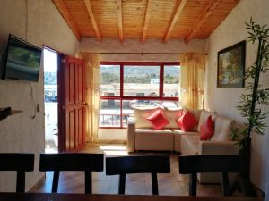 uma sala de estar com um sofá e uma grande janela em El Nuevo Mirador em Guatapé