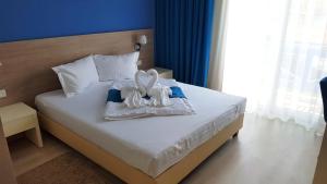 1 dormitorio con 1 cama con toallas en Pensiunea Blue House, en Murighiol