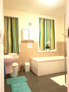 ein Badezimmer mit einem Waschbecken, einem WC und einer Badewanne in der Unterkunft Gabriel Guesthouse in Rhyl