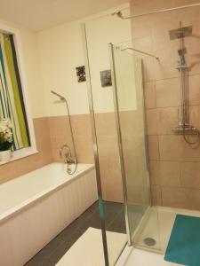 a bathroom with a shower and a bath tub at Gabriel Guesthouse in Rhyl
