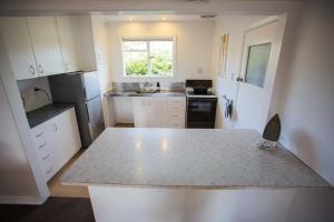 a kitchen with white cabinets and a counter top at 1 - Delightfully fresh, private home close to town in Wanaka