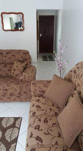 a living room with a brown couch and a mirror at Apto em Lindóia in Lindóia
