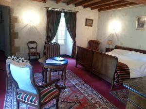 um quarto com uma cama, uma mesa e cadeiras em Chateau d'Ayres - Hôtel & Spa em Meyrueis