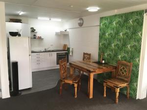 a kitchen with a wooden table and chairs and a refrigerator at Smart Apartment in Dinsdale