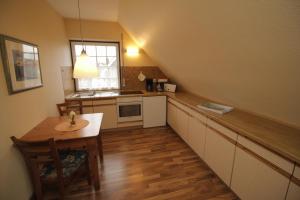 uma pequena cozinha com uma mesa de madeira e uma janela em Strandroggen em Wangerland
