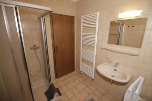 ein Badezimmer mit Dusche und Waschbecken in der Unterkunft Strandroggen in Wangerland