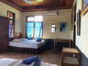 1 dormitorio con 2 camas y ventana en Bunaken Beach Resort New, en Bunaken