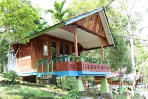 a small wooden house with a large balcony at Yulia Resort in Sabang