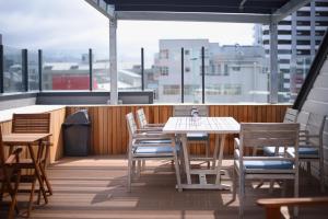 a patio with tables and chairs on a balcony at The Marion Hostel in Wellington