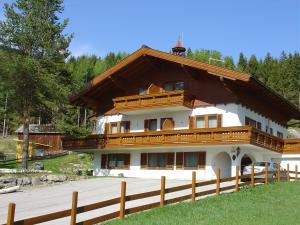 a large building with a wooden fence in front of it at Landhaus Dickhardt in Schladming