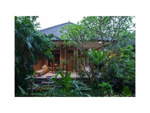 una casa con un jardín con árboles y plantas en In Da Garden, en Ubud