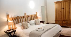 a bedroom with a large bed with white sheets and pillows at Matoppo Inn in Beaufort West