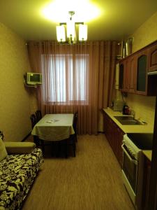 キスロヴォツクにあるApartment Sunのベッド1台、キッチン(テーブル付)が備わる小さな客室です。