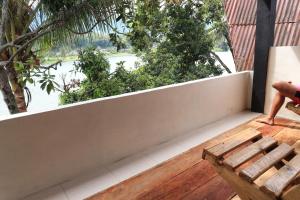 a balcony with a bench and a view of the water at Laster Jony's in Tuk Tuk