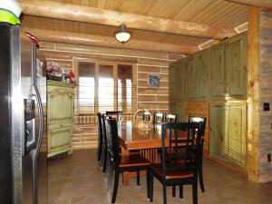 a kitchen with a table and chairs and a refrigerator at Teton Hostel HideAway in Driggs