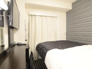ein Hotelzimmer mit einem Bett und einem Fenster in der Unterkunft APA Hotel Mito-eki Kita in Mito