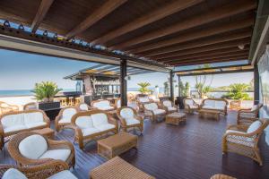 a patio with chairs and tables and the ocean at Hotel Ambassador in Tortoreto Lido