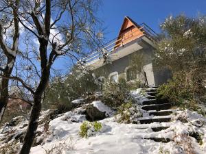 a house on a snow covered hill with stairs at Chalet Etna Mareneve Milo in Fornazzo
