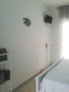 アグローポリにあるBrezza Del Mareの白いベッドルーム(ベッド1台、窓付)