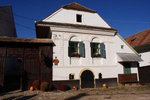 een wit gebouw met twee ramen en een deur bij Pensiunea ARANYOS in Rimetea