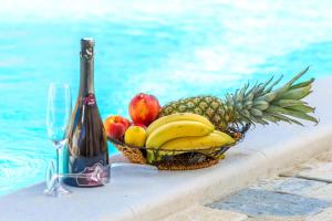 uma cesta de frutas sentada ao lado de uma garrafa de vinho em Holiday home Iva with pool em Sukošan