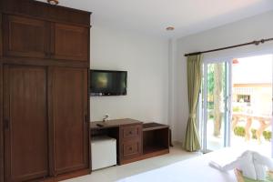 una camera da letto con un grande armadio in legno e una TV di Shangrilah Bungalow a Mae Nam