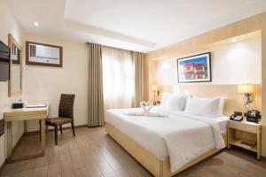 Habitación de hotel con cama grande y escritorio. en Golden Prince Hotel & Suites en Cebú