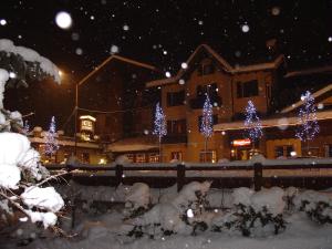 Una casa con luces de Navidad en la nieve en Hotel Dei Camosci, en Courmayeur