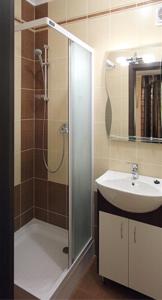 een badkamer met een douche en een wastafel bij Maxima in Kamjanets-Podilsky