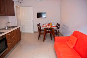 een keuken met een tafel en een rode bank in een kamer bij Dimora De Mauro in Catania