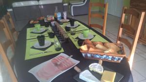 een tafel met eten en een mand met brood erop bij L'Escapade in Vertus