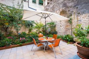 a table and chairs with an umbrella on a patio at Porta Dipinta House Bergamo Alta in Bergamo