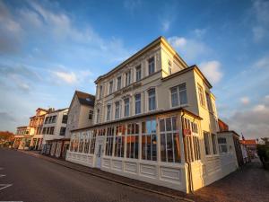a white building on the side of a street at Hotel Weisse Düne in Borkum