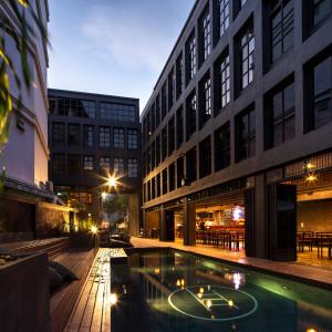 un edificio con piscina en medio de un patio en BED STATION Hostel Khaosan, en Bangkok