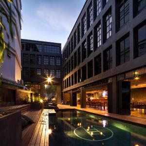 un edificio con piscina en medio de un patio en BED STATION Hostel Khaosan en Bangkok