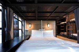 曼谷BED STATION Hostel Khaosan的一间卧室配有一张大床和一张黑色的书桌