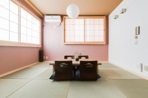 a dining room with a table in a room with windows at GuestHouse MIYABI in Kyoto