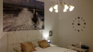 Pokój z łóżkiem i zegarem na ścianie w obiekcie B&B Metropolitan Taranto w mieście Tarent