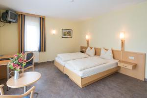 ein Hotelzimmer mit einem Bett und einem Tisch in der Unterkunft Hotel Burg Hof in Burg-Reuland